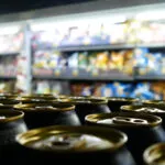 Many beautiful golden black cans of beer on a store shelf close-up