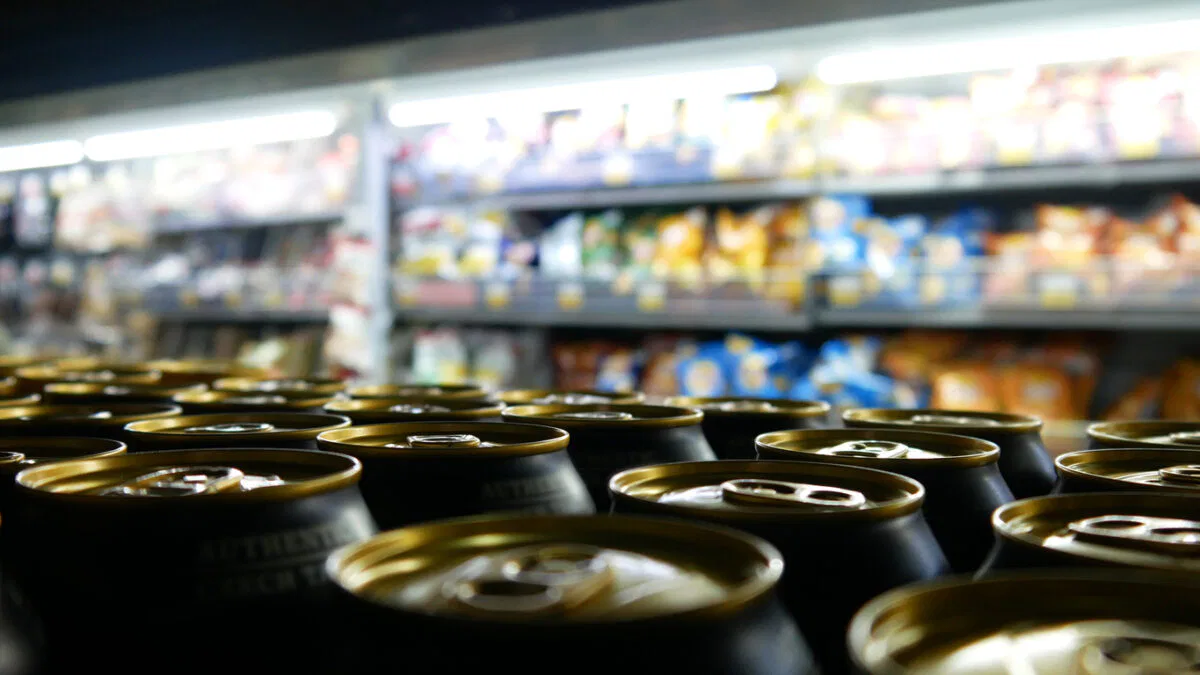 Many beautiful golden black cans of beer on a store shelf close-up