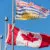 Canada and British Columbia flags waving over blue sky in Vancouver, BC, Canada